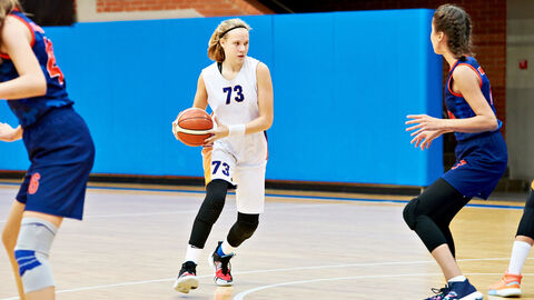 Junge Frau beim Basketballspiel