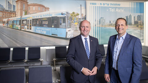 Antisemitismusbeauftragter Uwe Becker mit Fraport-Vorstand Dr. Pierre Dominique Prümm vor der neuen Fotowand