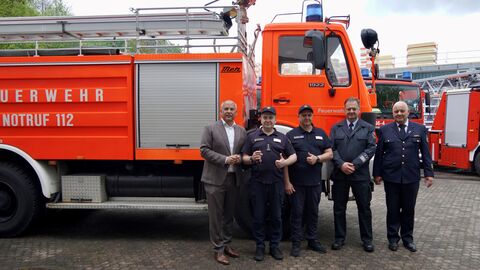 Innenminister Roman Poseck mit zwei ukrainischen Feuerwehrmännern, Karlheinz Moll (Stadtbrandinspektor Bad Vilbel) und Erwin Baumann (Direktor der HLFS) bei der Fahrzeugübergabe