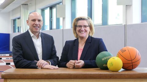 Entbürokratisierungsminister Pentz steht neben der Präsidentin des Landessportbundes, Juliane Kuhlmann. Sie stehen an einem Sportgerät.