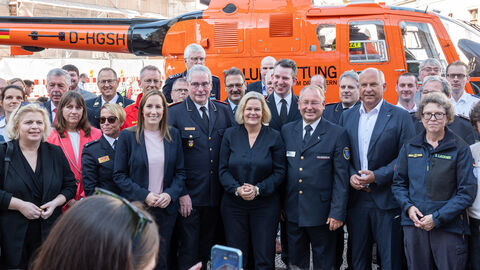 : Bundesinnenministerin Nancy Faeser, Innenminister Roman Poseck, Landtagspräsidentin Astrid Wallmann, Oberbürgermeister Gert-Uwe Mende stehen gemeinsam mit Einsatzkräften vor Rettungshubschrauber