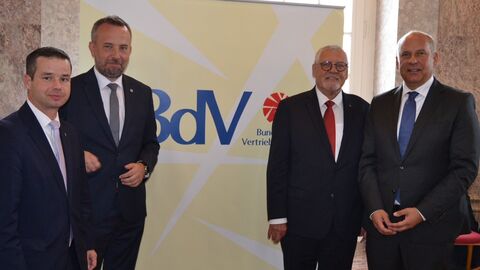 Andreas Hofmeister MdL, Landesbeauftragte für Heimatvertriebene und Spätaussiedler, Rafał Bartek Vorstandsvorsitzender des Verbandes der deutschen sozial-kulturellen Gesellschaften in Polen (VdG), Siegbert Ortmann Vorsitzender des Landesverbandes Hessen e.V. im Bund der Vertriebenen und Innenminister Roman Poseck  Innenminister Roman Poseck steht mit drei weiteren Männern vor einem Plakat mit der Aufschrift BdV - Bund der Vertriebenen.
